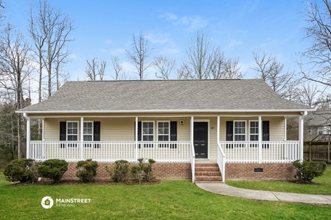 a house with a white porch and a grassy yard
