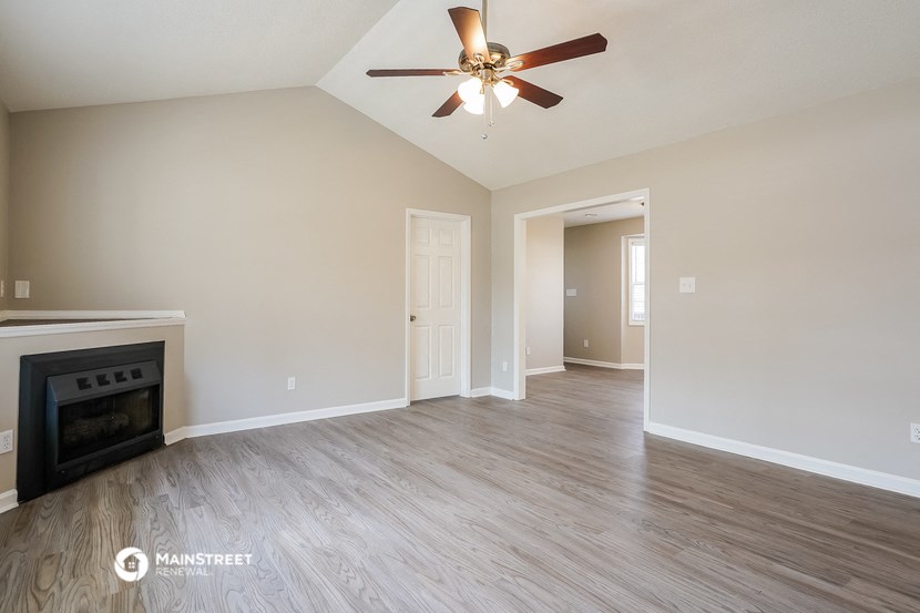 the living room with fireplace and ceiling fan