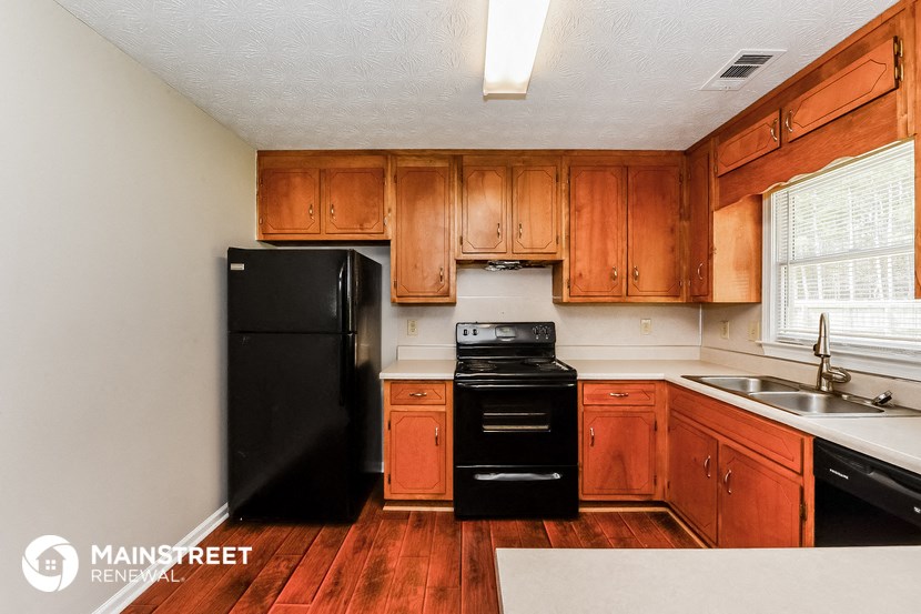 a kitchen with black appliances and wooden cabinets