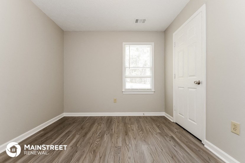 the interior of a room with wooden floors and a white door