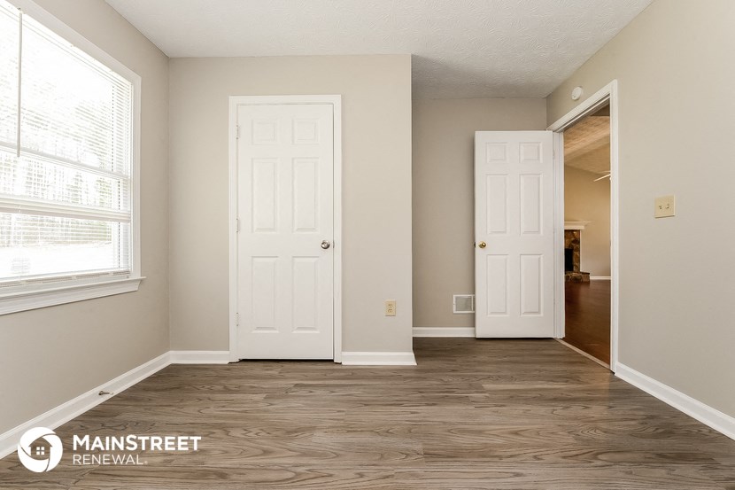 a living room with two doors and a door to a hallway