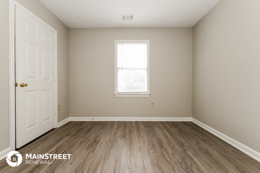 the interior of an empty room with wooden floors and a window