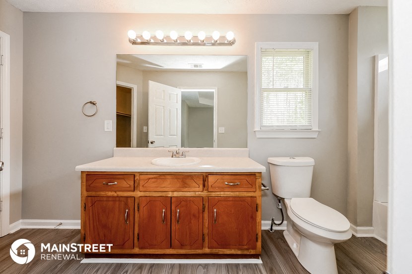 a bathroom with a sink toilet and a mirror