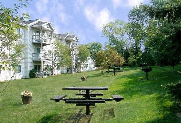 a picnic table in a park in front of a house