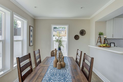 a dining room with a wooden table and chairs