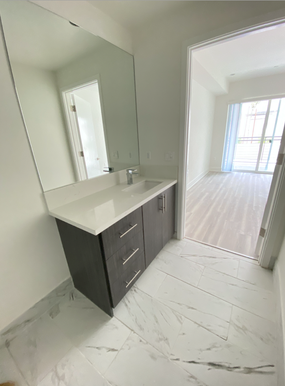 an empty bathroom with a sink and a large mirror