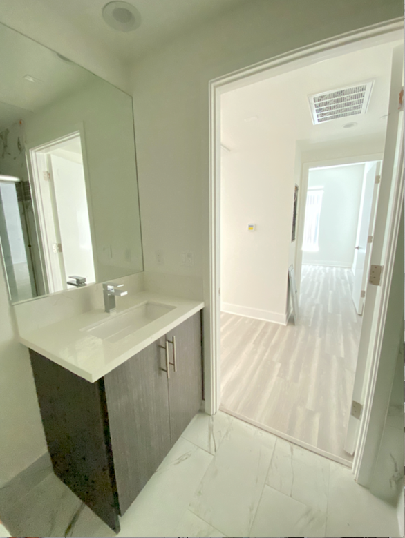 an empty bathroom with a large mirror and a sink