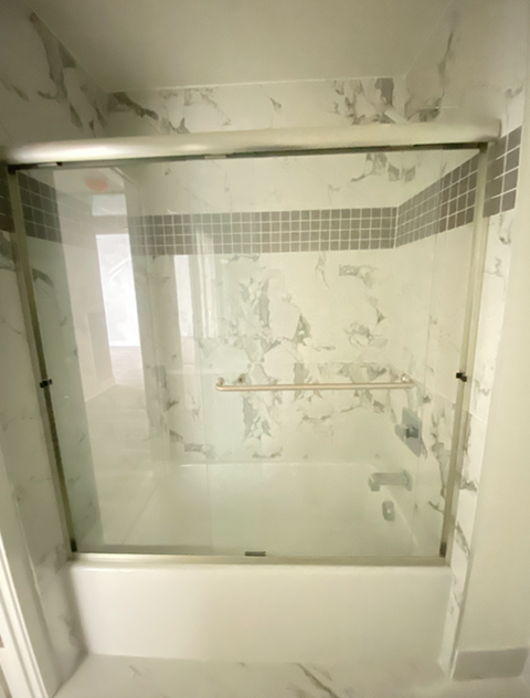 a bathroom with a shower with a glass door