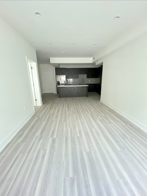 an empty living room and kitchen in a new home