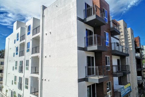 the side of a building with balconies and a blue sky