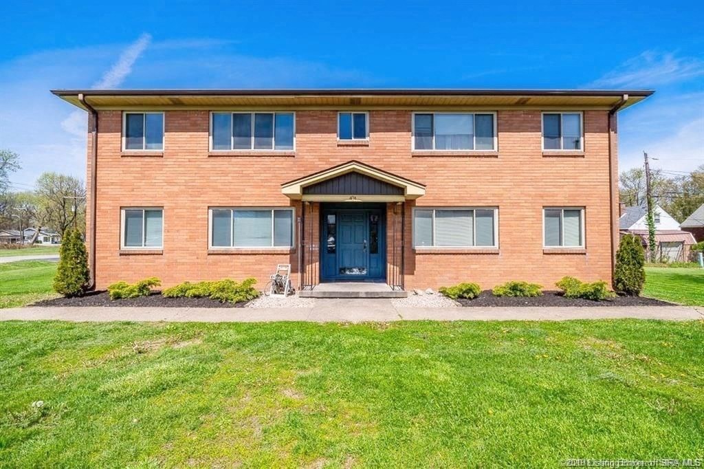 the front of a brick house with a blue door