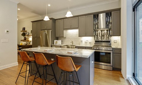 a kitchen with a large island with four chairs