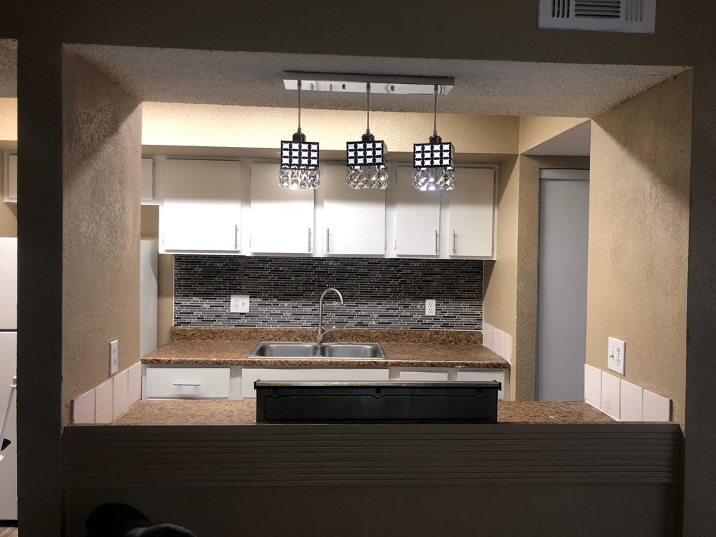 a kitchen with white cabinets and a counter top