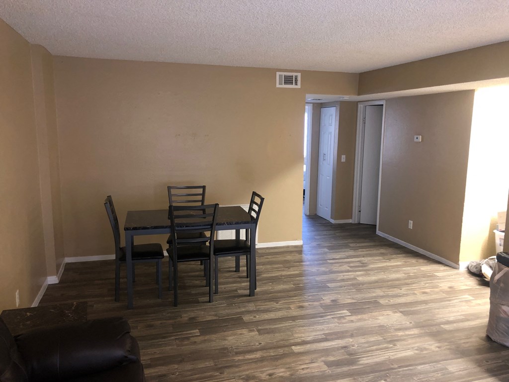 a dining room and living room with a table and chairs