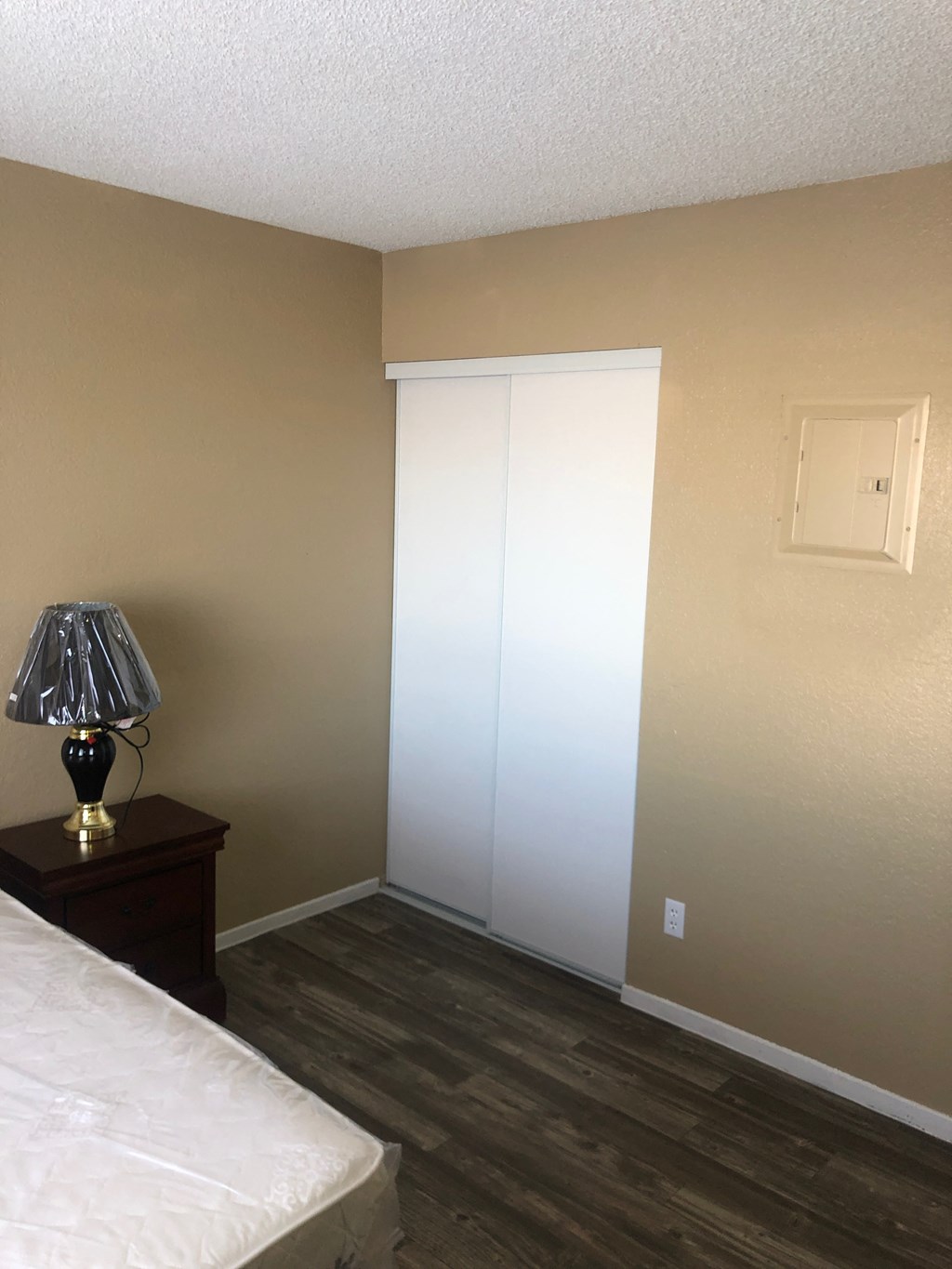 a bedroom with a white closet and a lamp on a table