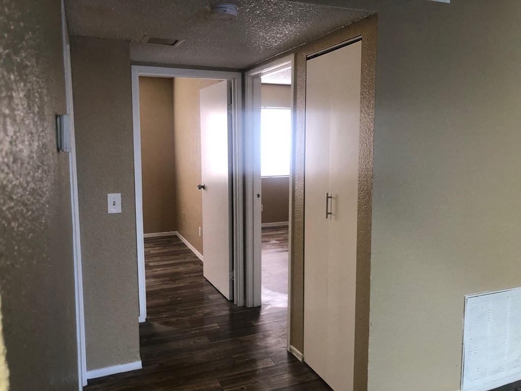 a look into the living room from the dining room and the hallway to the bedrooms