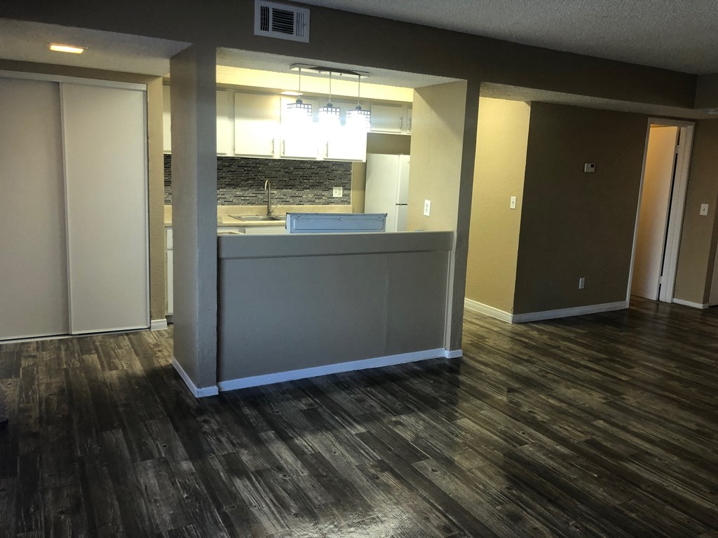 an empty living room with a kitchen in it