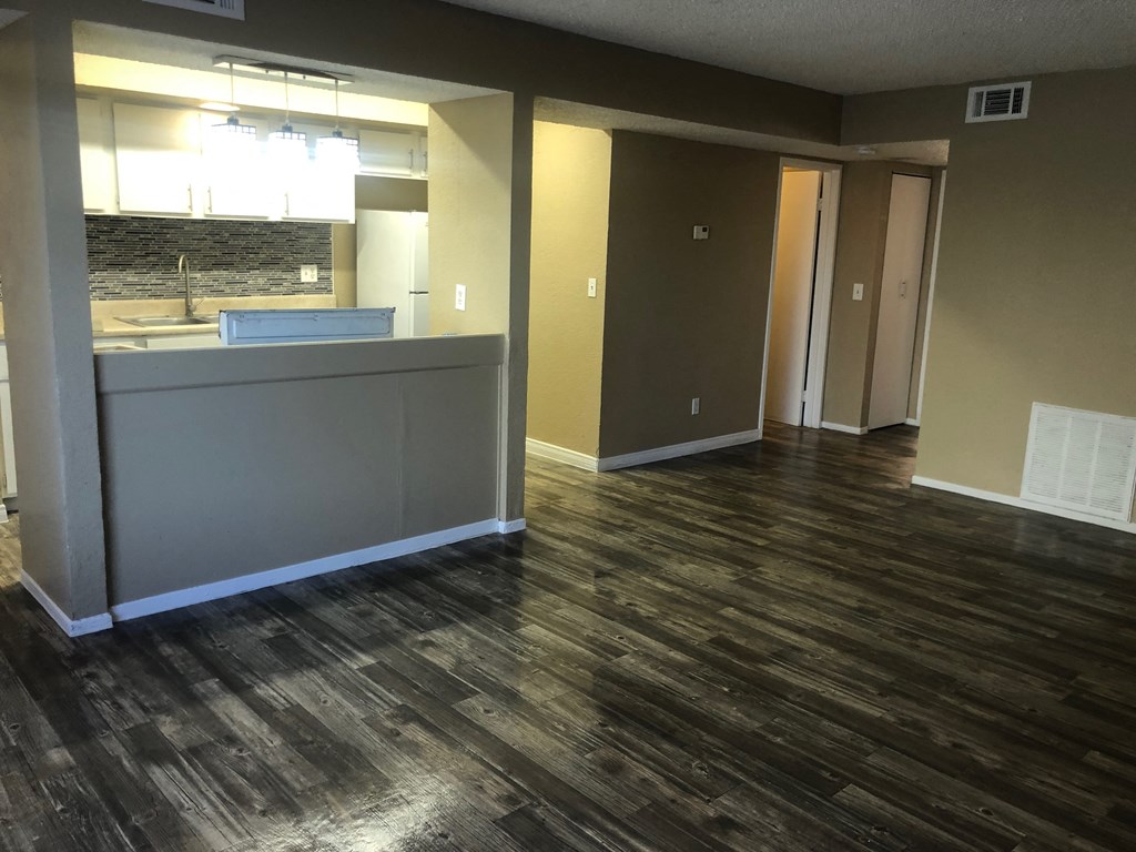 a kitchen and living room with wood flooring in a house