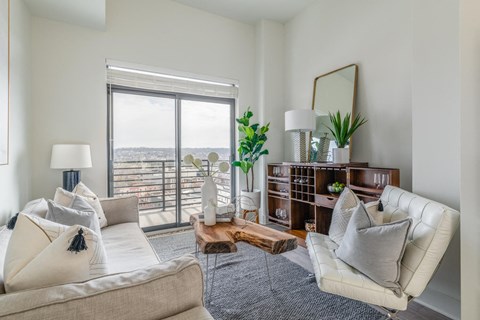 a living room with white furniture and a large window