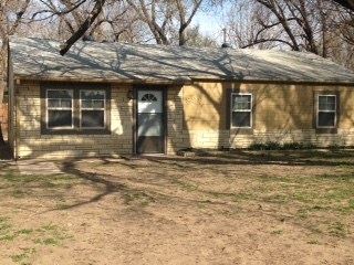 a small house in the middle of a dirt field