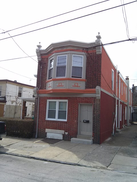 A red brick house with a white door and windows.
