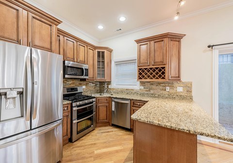 A kitchen with wooden cabinets and granite countertops.