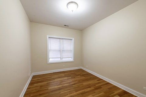 A room with wooden flooring and a window.