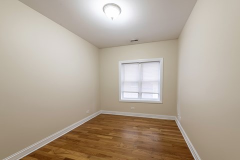 A room with a window and wooden flooring.