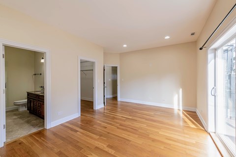 A large empty room with wooden floors and white walls.