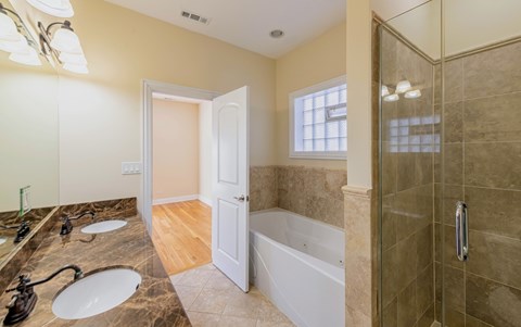 A bathroom with a tub, sink, and shower.