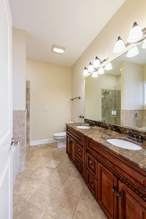 A bathroom with a sink, mirror, and toilet.