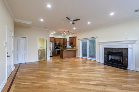 A spacious living room with a fireplace and wooden floors.