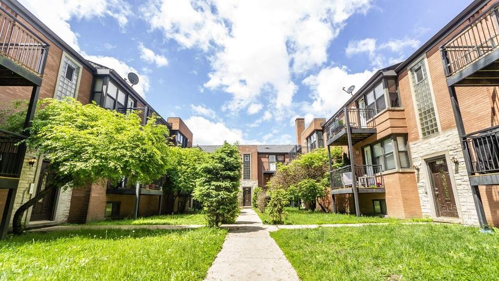 a row of houses with grass and trees