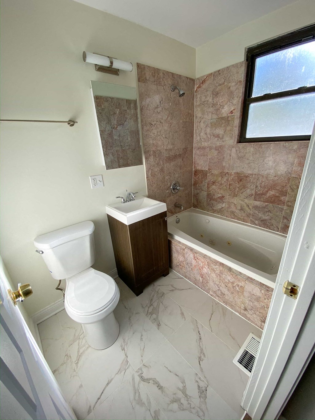 a bathroom with a toilet and a tub and a sink