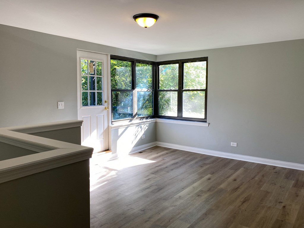 an empty kitchen with hardwood floors and a window