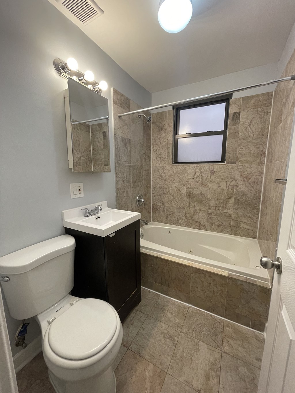 a bathroom with a toilet and a tub and a sink