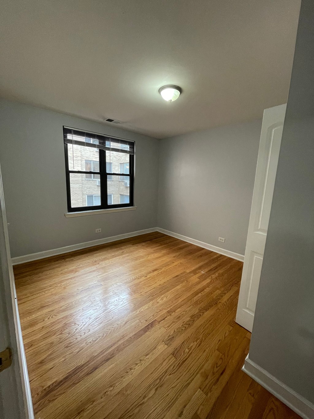 a living room with wood floors and a window