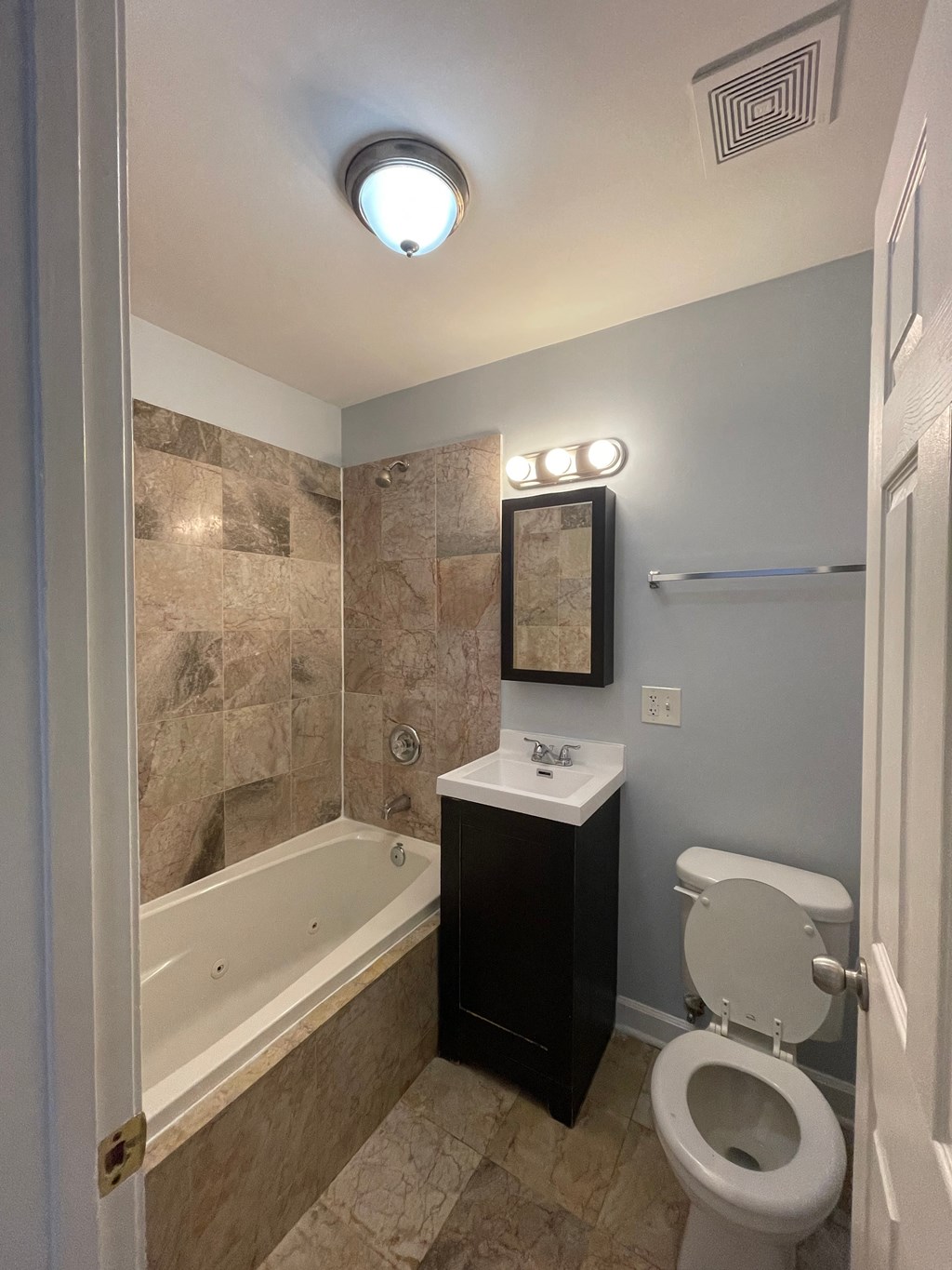 a bathroom with a toilet and a tub and a sink