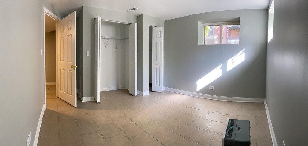an empty living room with a hallway and a door to a closet