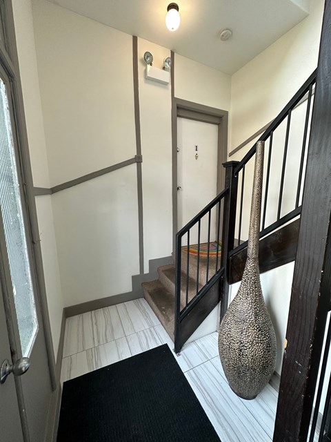 a stairwell in a home with a vase on the floor