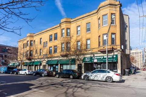 A street view of a building with cars parked in front and a sign that says "Lonny Mac's.".