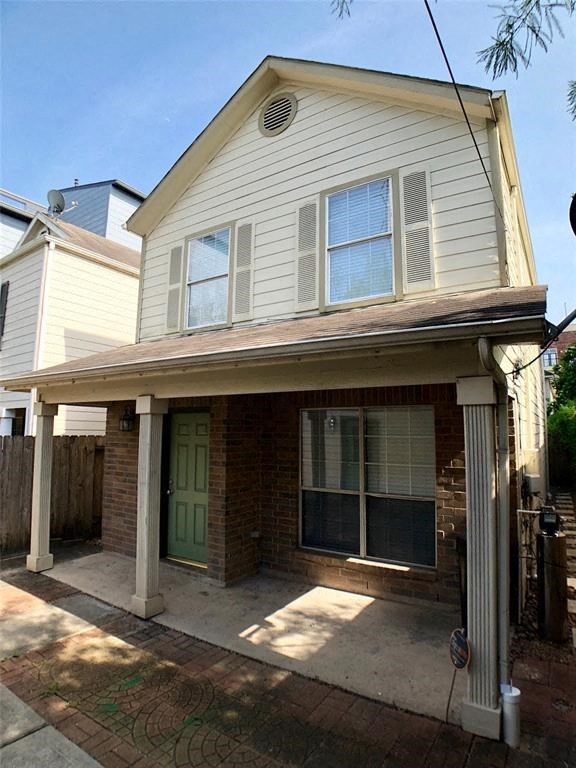 a white house with a porch and a driveway