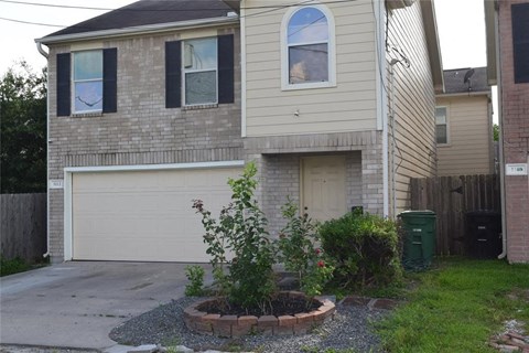 a white brick house with a garage and a driveway