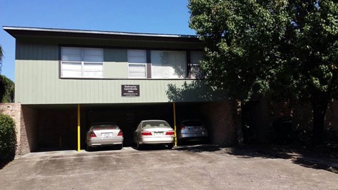 a building with three cars parked in a parking lot
