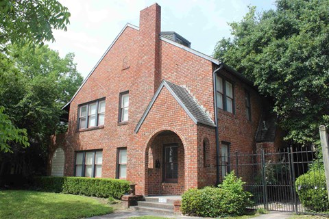 a red brick house with a black fence