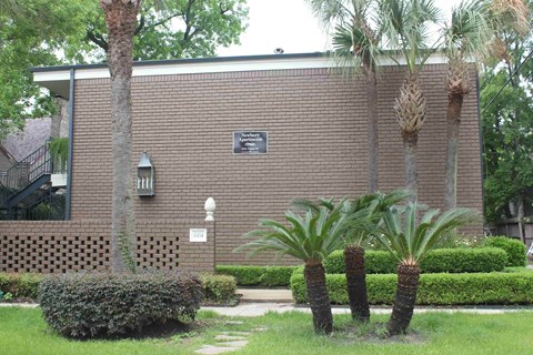 a brick building with palm trees in front of it