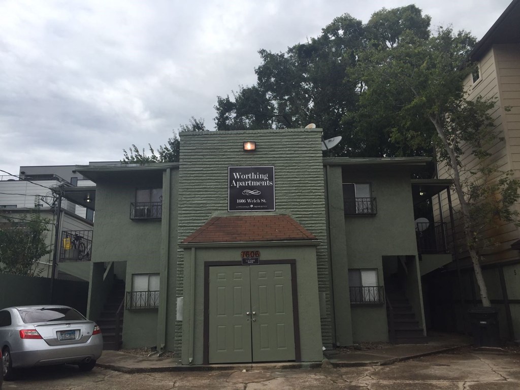 the front of a green building with a green garage door