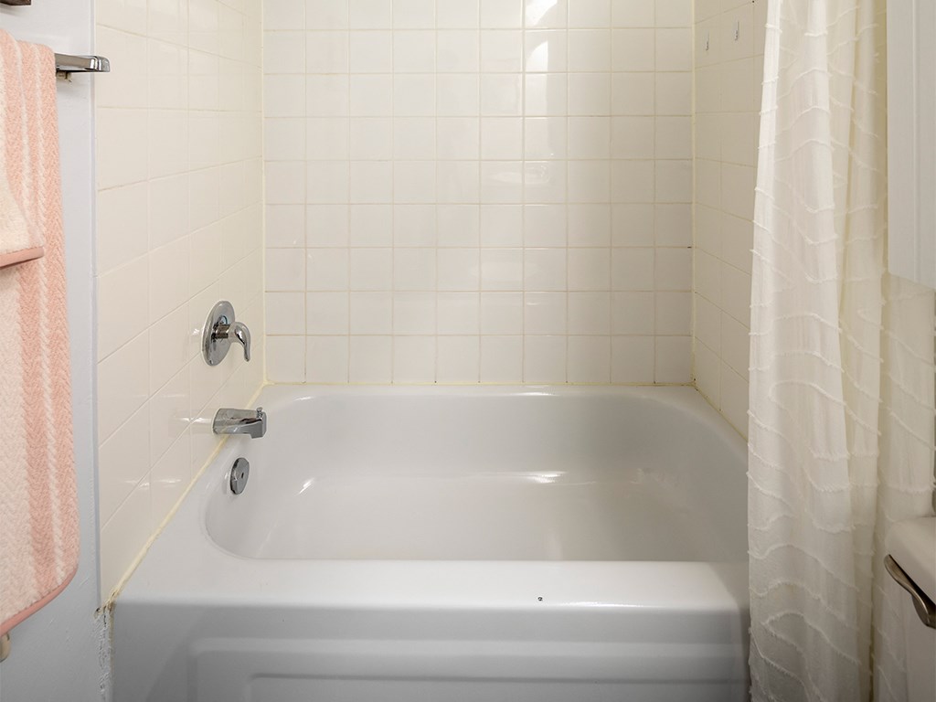 a bathroom with a white tub and a shower curtain