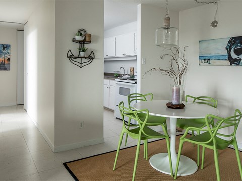 a kitchen and dining room with green chairs and a white table