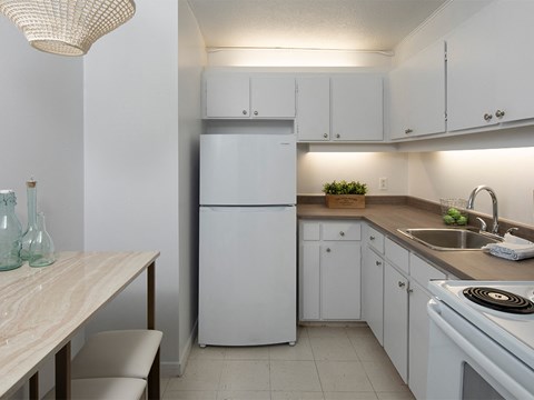 a kitchen with white cabinets and a sink and a refrigerator